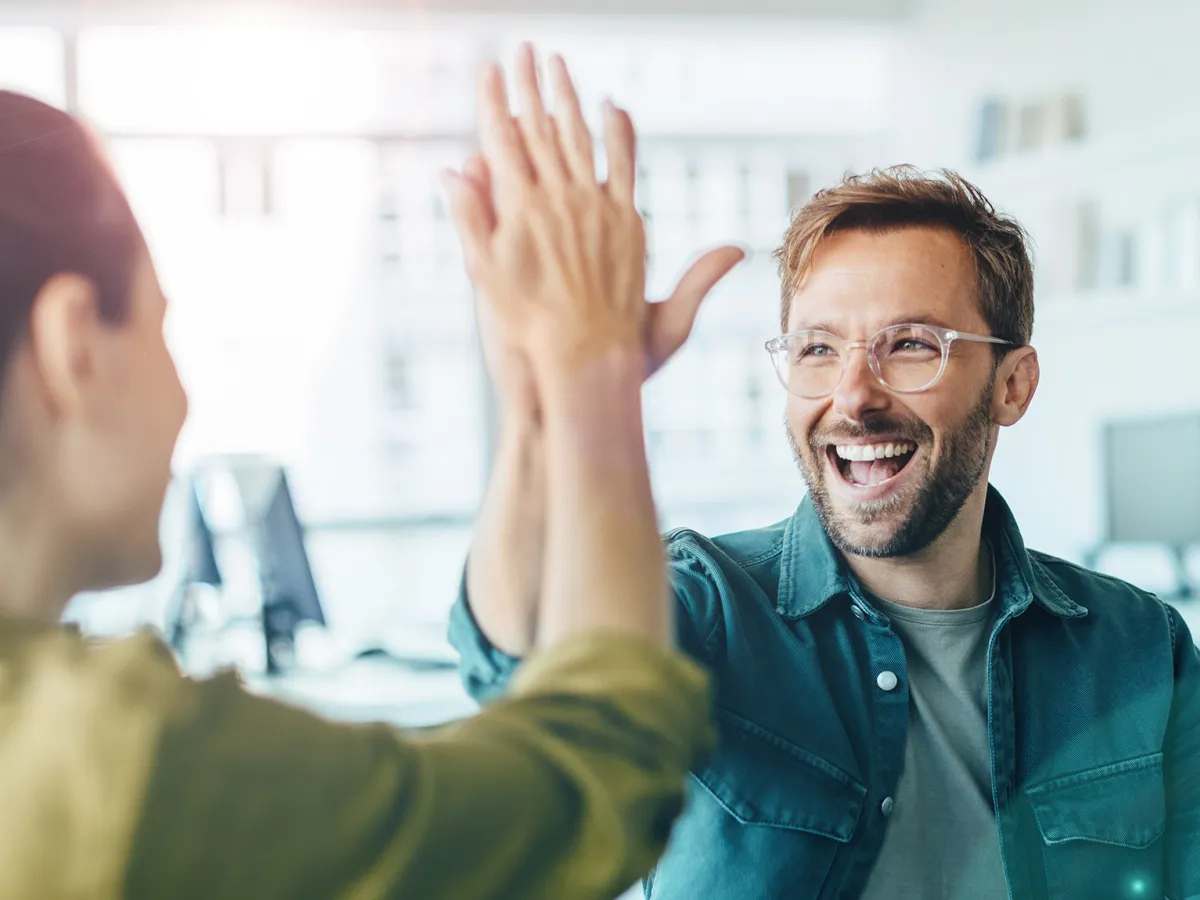  Ein Mann und eine Frau klatschen begeistert in die Hände, symbolisierendes Teamgeist und gemeinsamen Erfolg. Die Szene strahlt positive Energie, Zusammenarbeit und gegenseitige Unterstützung aus.